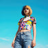 A colorful 90s-style mesh crop top featuring a maximalist abstract pattern. This see-through shirt has a high mock neck, short sleeves, and a vibrant, retro design with geometric shapes, color blocking, and polka dots in bold shades of pink, yellow, blue, and orange. The Y2K-inspired top is a statement piece of festival clothing, perfect for a rave outfit or alternative, dopamine-dressing-inspired streetwear looks.